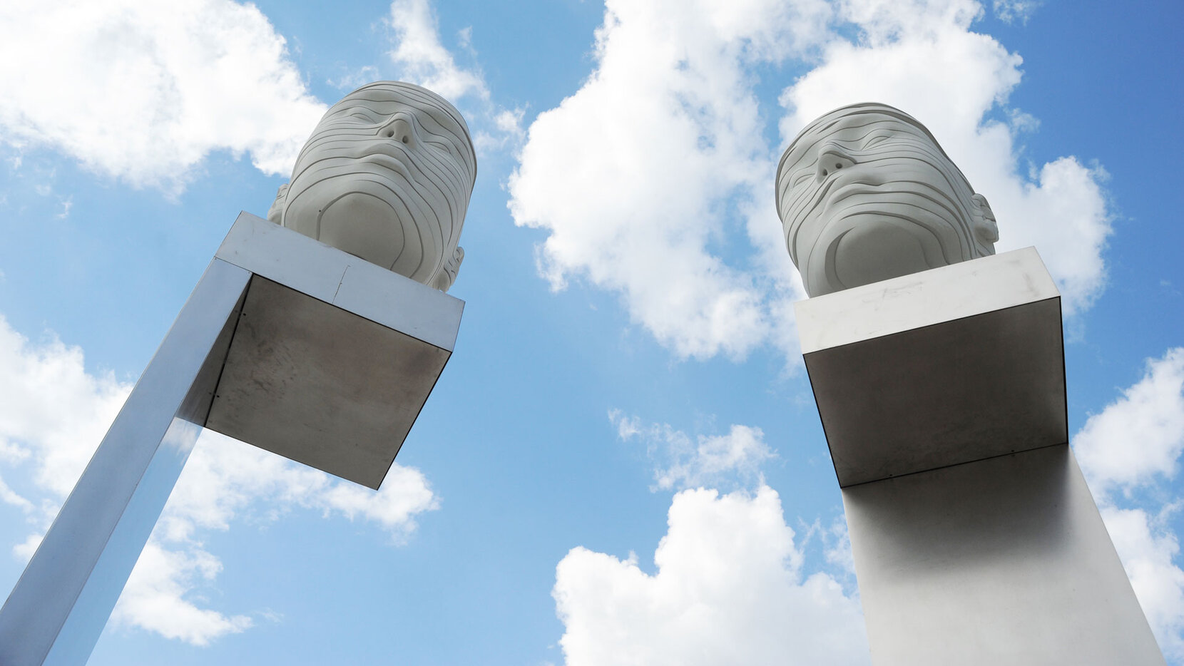 Die beiden steinernen Köpfe vor dem Forum Adlershof von unten.